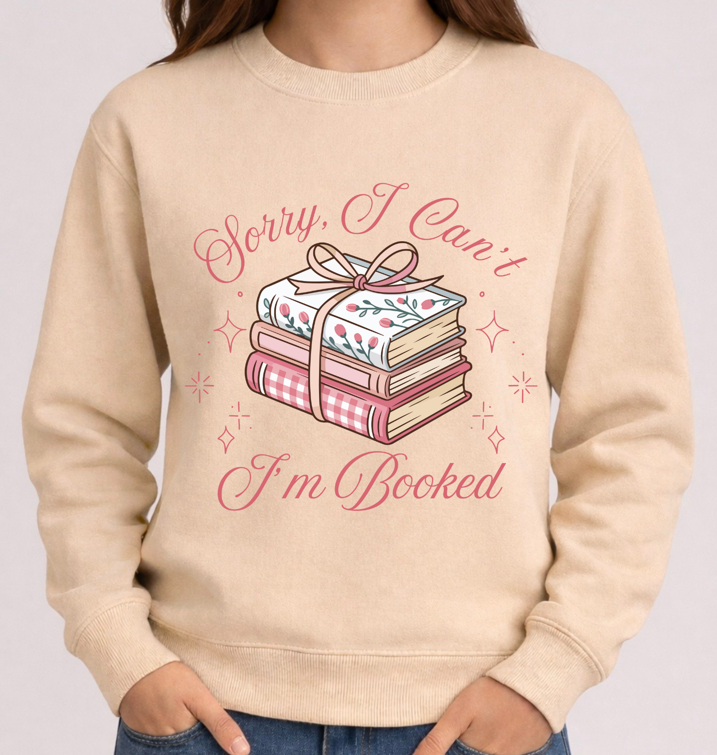 Beige sweatshirt with book-themed design and text on a plain background