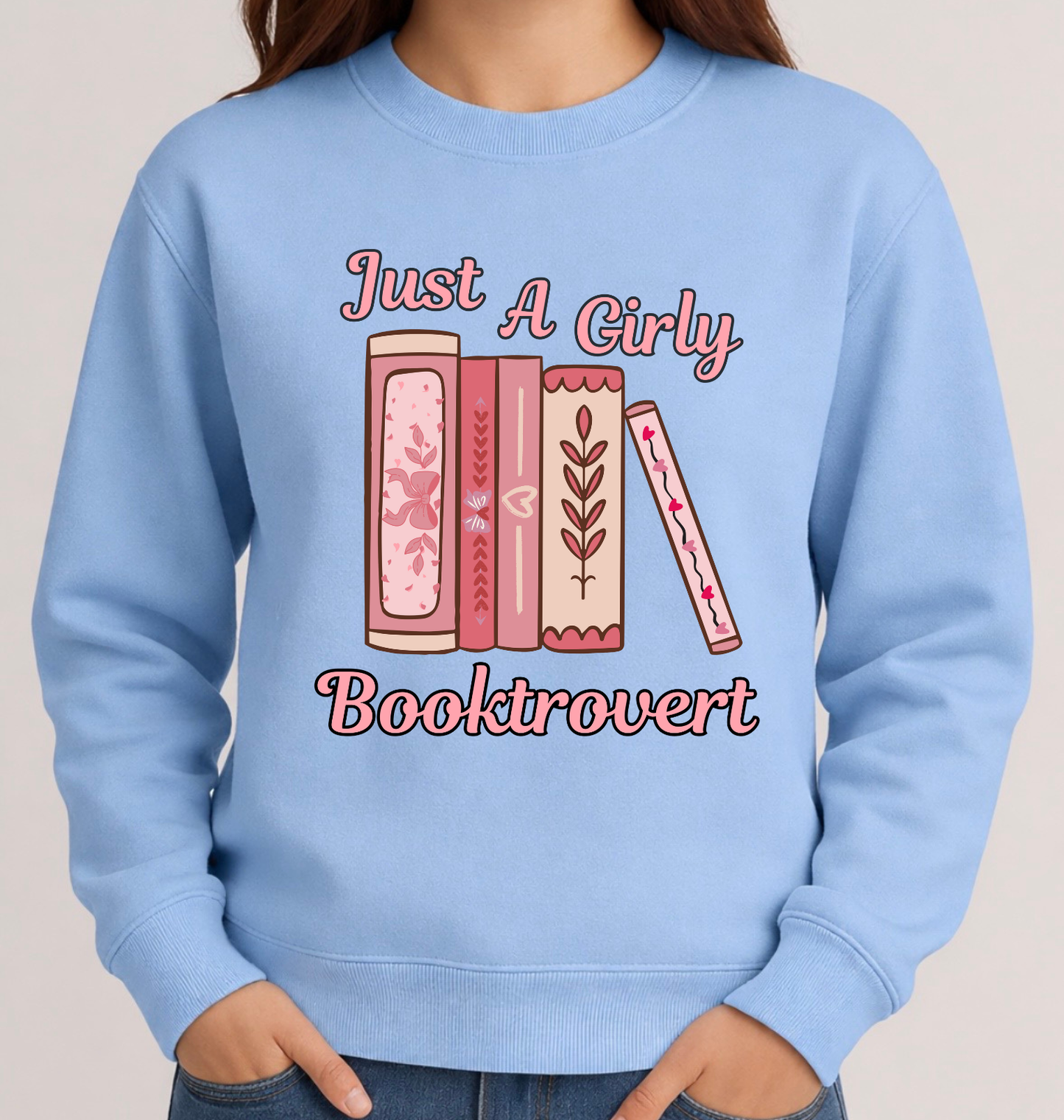 Light blue sweatshirt with book-themed design and text on a neutral background